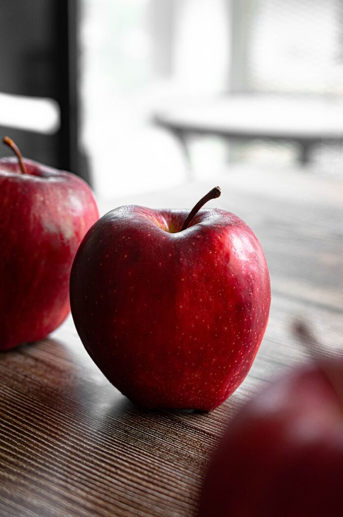Photo by Sara Cervera red apple on brown wooden table