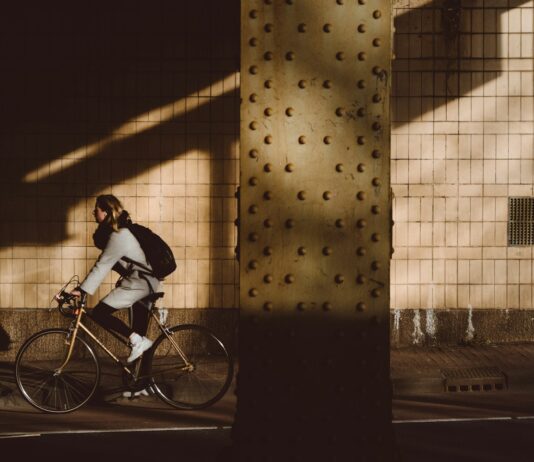 건강한 몸과 마음을 위한 자연식과 운동 루틴 person biking under highway