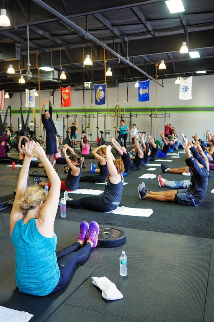 Photo by Photo Genius people doing yoga inside gym