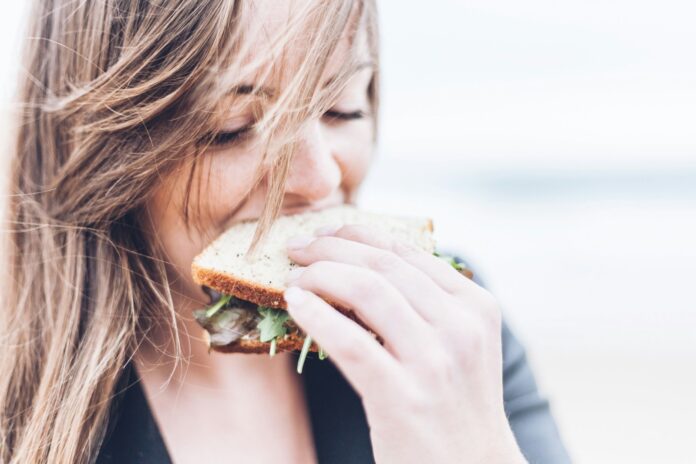 Photo by Gardie Design & Social Media Marketing woman eating sandwich