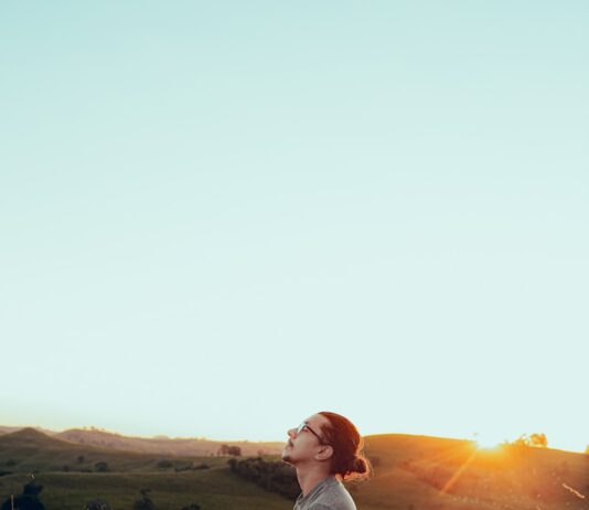 마음을 가다듬어 건강을 찾는 방법 man in white shirt sitting on green grass field during sunset