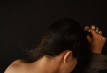 “어깨가 항상 묵직해요”… 거북목에서 시작된 ‘신경통’ 신호일 수 있습니다 a woman in a brown dress holding her hair back