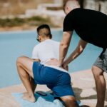 “남자가 무슨 필라테스?” 편견 깨고 조용히 급증하는 ‘맨즈 필라테스’ 열풍 man in black shirt assisting man in white shirt