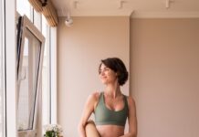 필라테스, 내 몸과 마음을 돌보는 건강한 일상의 선택 a woman in a green sports bra top and leggings holding a yoga mat